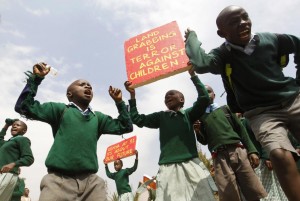 Students from Langata primary school hold placards as they protest against a perimeter wall illegally erected by a private developer around their school playground in Nairobi