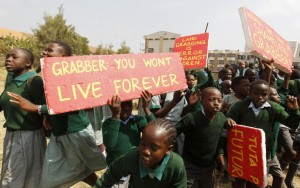 Students from Langata primary school hold placards as they protest against a perimeter wall illegally erected by a private developer around their school playground in Nairobi