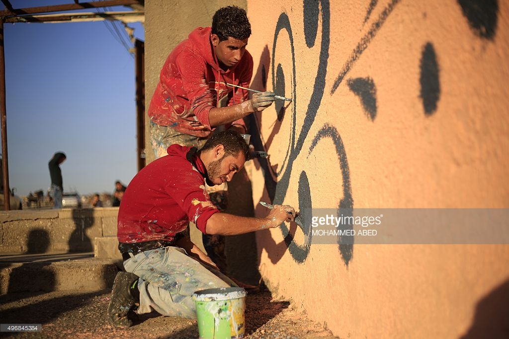 palestinian-artists-paint-the-facade-of-a-house-in-the-alshati-camp-picture-id496845384